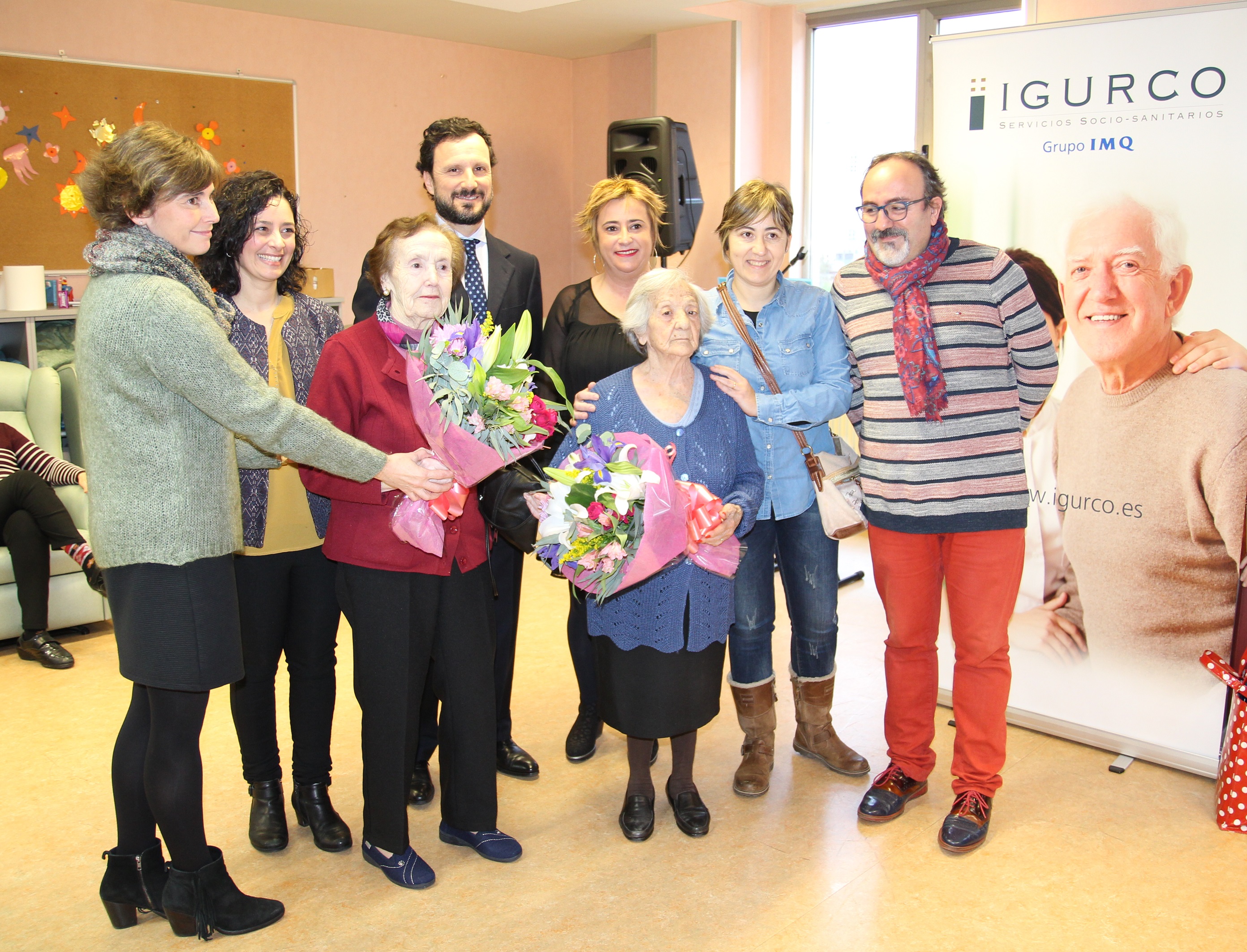 Momento de la entrega de dos ramos de flores a Daniela Quirce y Basilisa Díez, dos de las usuarias más veteranas del centro de día de Leioa gestionado por IMQ IGURCO.